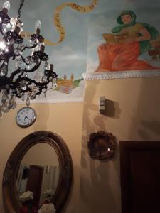 a room with a mirror and a painting and a clock at Affittacamere Alex in Rome
