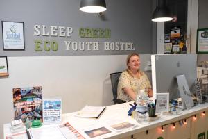 een vrouw aan een bureau in een kamer bij Sleep Green - Certified Eco Youth Hostel in Barcelona