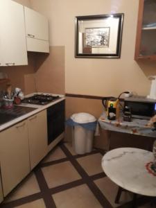a small kitchen with a stove and a table at Affittacamere Alex in Rome