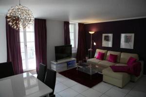 een woonkamer met een bank en een tv bij Swiss Interlaken Apartment in Interlaken