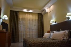 a hotel room with a bed and a window at Hotel Diamantidis in Myrina