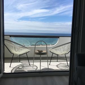 2 stoelen en een tafel op een balkon met uitzicht op de oceaan bij Salty House - Casa Salgada in Foz do Arelho