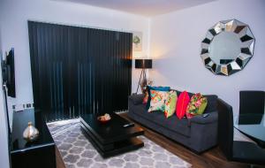 a living room with a couch and a mirror at MODERN 2 BEDROOM APARTMENT in London