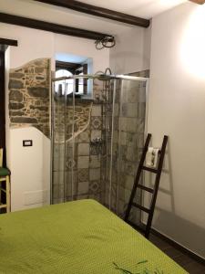 y baño con ducha y mesa verde. en Al castello San Piero Patti, en San Piero Patti