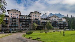 a large building with a park in front of it at Residence Grand Hotel Carezza in Nova Levante