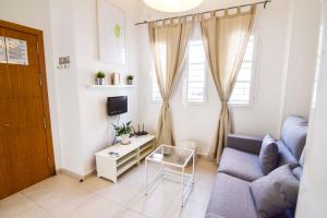 sala de estar con sofá y TV en Malaga City Suites Barceló 30, en Málaga