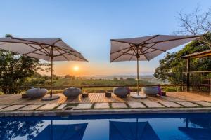 a villa with a pool with umbrellas at Bluemere Living in White River +26 photos