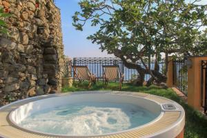 a hot tub in a yard with two chairs at Agave Room Rental in Riomaggiore