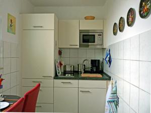 una pequeña cocina con armarios blancos y microondas en Ferienwohnung-Wiesbaden-Top3 en Wiesbaden