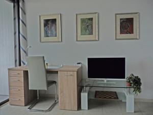 ein Büro mit einem Schreibtisch mit einem Monitor und einem Stuhl in der Unterkunft Ferienwohnung-Wiesbaden-Top3 in Wiesbaden