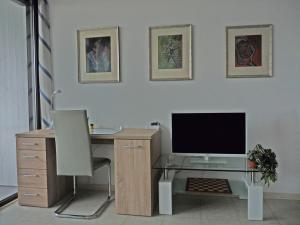 an office with a desk with a monitor and a chair at Ferienwohnung-Wiesbaden-Top3 in Wiesbaden