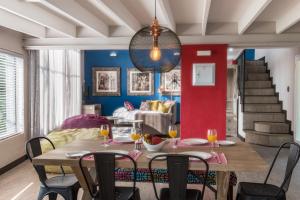 comedor con mesa, sillas y pared roja en Bluemere Living en White River