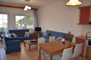 a living room with a blue couch and a table at Amigdaleonas House in Amigdhaleón