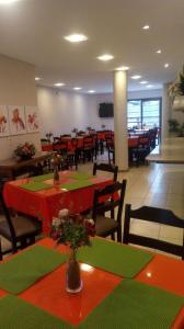 a restaurant with red and green tables and chairs at Vital Hotel in Marechal Floriano
