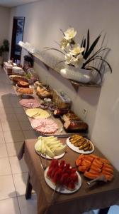 einem langen Tisch mit verschiedenen Lebensmitteln in der Unterkunft Vital Hotel in Marechal Floriano