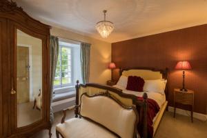 a bedroom with a bed and a mirror and a window at Altskeith Country House in Aberfoyle