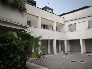 a large white building with a palm tree in front of it at Villa Zen 2 in Padova