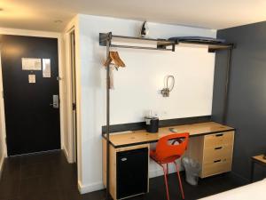 a room with a desk and a red chair at Bklyn House Hotel New York Brooklyn in Brooklyn