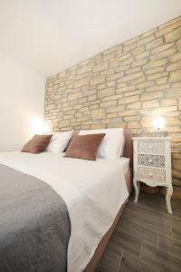 a bedroom with a large bed and a stone wall at Saint Simeon room and apartment in Zadar
