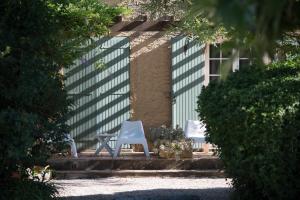 two white chairs and a table in front of a building at Logis Hôtel Castel Mouisson in Barbentane