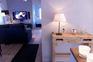 a living room with a couch and a table with a lamp at Die Mühle Appartements in Samtens