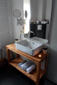 a bathroom with a sink and a mirror and towels at Die Mühle Appartements in Samtens +26 photos