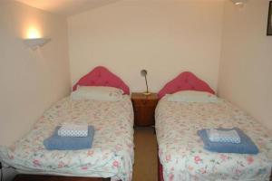 a bedroom with two beds with blue and white sheets at Neuadd Arms Hotel in Llanwrtyd Wells +2 photos