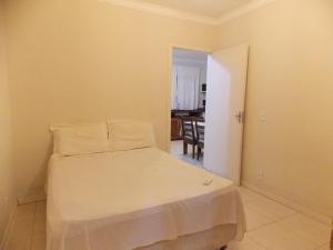 1 dormitorio con 1 cama blanca en una habitación en 02 - CASA praia PINHEIRA pousada, en Palhoça
