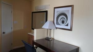 a desk with a lamp on it in a room at Village Motor Inn in Austin