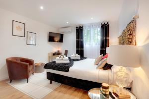 a bedroom with a king sized bed and a chair at La Villa Des Sens in Lattes