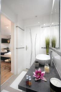 a bathroom with a white tub and a sink and a bath room at La Villa Des Sens in Lattes