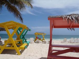 una playa con sillas y sombrillas y el océano en The Marlin at Taino Beach Resort, en Freeport