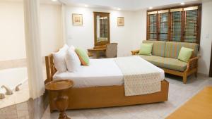 a bedroom with a bed and a couch and a tub at The Marlin at Taino Beach Resort in Freeport