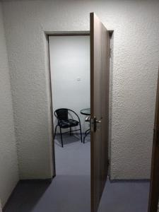 una puerta abierta a una habitación con silla en Comfort Plus en Tiflis