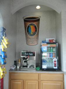 a coffee shop with a giant cup on the wall at Village Inn & Suites - Smithville in Smithville