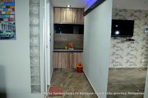 a hallway of a kitchen with a sink and a tv at Micky Santoro -Apartments in Bantayan Island