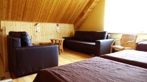 ein Wohnzimmer mit einem Sofa, einem Sofa und einem Stuhl in der Unterkunft Raudonkalnis in Mankiškiai
