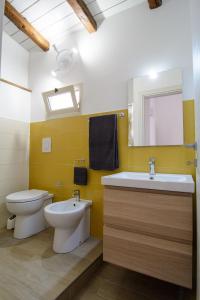 een badkamer met een toilet, een wastafel en een spiegel bij Ficodì apartments in Alcamo