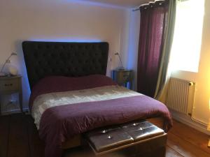 a bedroom with a bed with a purple blanket and a window at notre maison à Eguisheim in Eguisheim