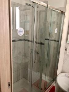 La salle de bains est pourvue d'une douche avec une porte en verre. dans l'établissement Paphos gardens studio suite, à Paphos