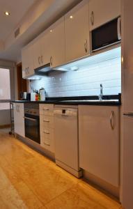 een keuken met een spoelbak en een fornuis bij Luxury City Center Apartment by NRAS in Alicante
