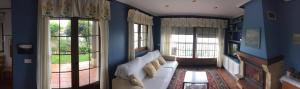 a living room with a white couch and two windows at Apartamentos Carmen de Castro in Comillas