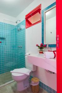 W łazience znajduje się toaleta, umywalka i lustro. w obiekcie Pousada Rosa dos Ventos w mieście Praia do Forte