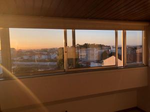 a window in a room with a view of the sunset at Casa Marquês in Porto