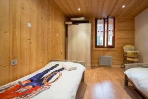 a bedroom with a bed and a wooden wall at Résidence Mont Joly2 in Saint-Gervais-les-Bains