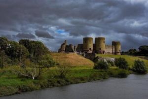 a castle sitting on top of a hill next to a river at Garden Suite in Rhuddlan