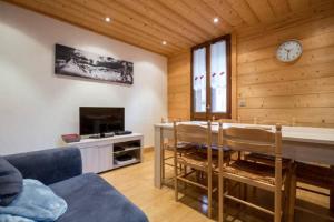 a living room with a table and a clock on the wall at Résidence Mont Joly2 in Saint-Gervais-les-Bains