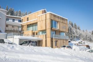 ein Gebäude im Schnee mit vor der Tür geparkt in der Unterkunft Appartements Luna in Flachau