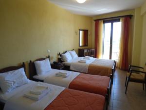 a hotel room with two beds and a window at Villa Belles in Akritochori
