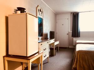 a room with a desk and a refrigerator in it at Manitou Motor Inn in Manitou